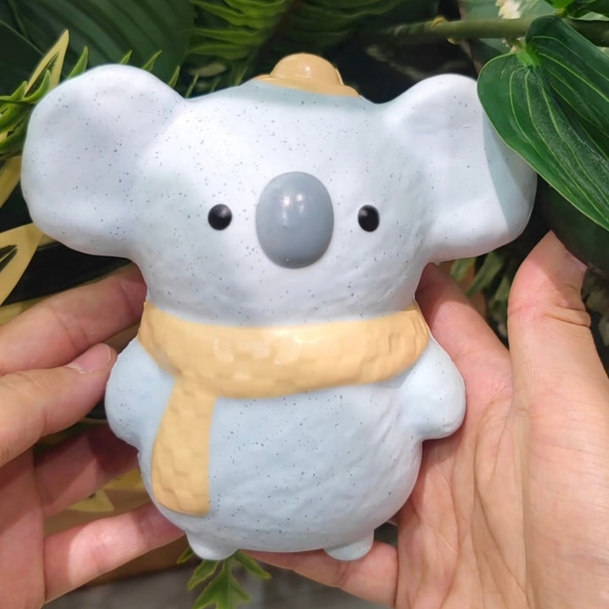 Juguete sensorial antiestrés premium con forma de koala azul y bufanda amarilla, con un aplastamiento súper suave y rebote lento.