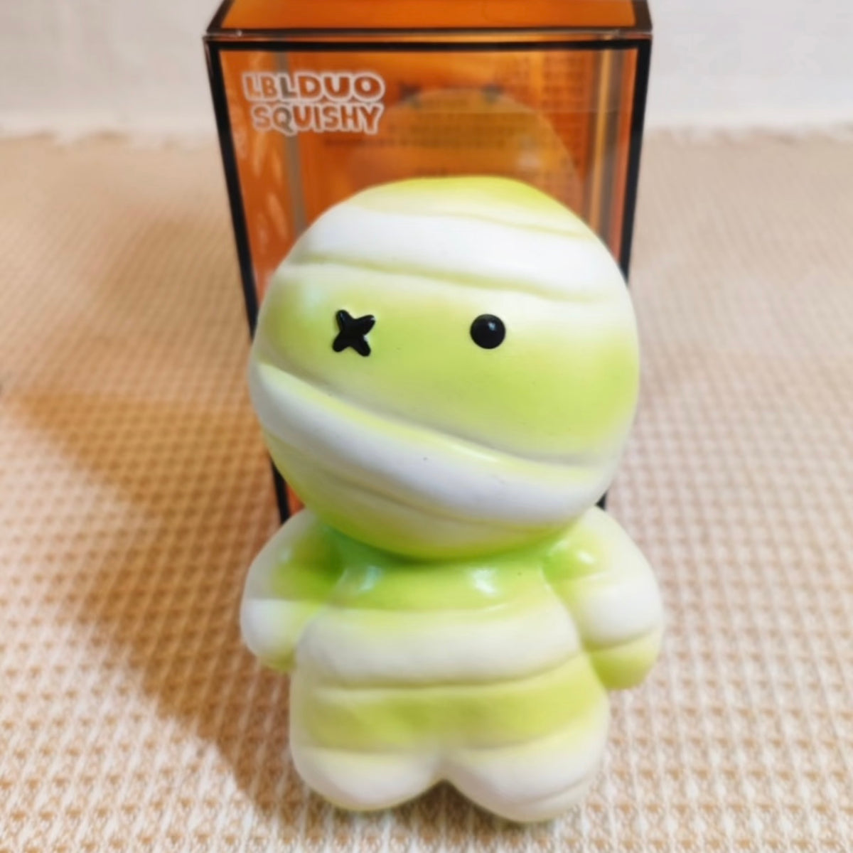 Juguete sensorial antiestrés premium de momia verde con un aplastamiento súper suave y rebote lento.