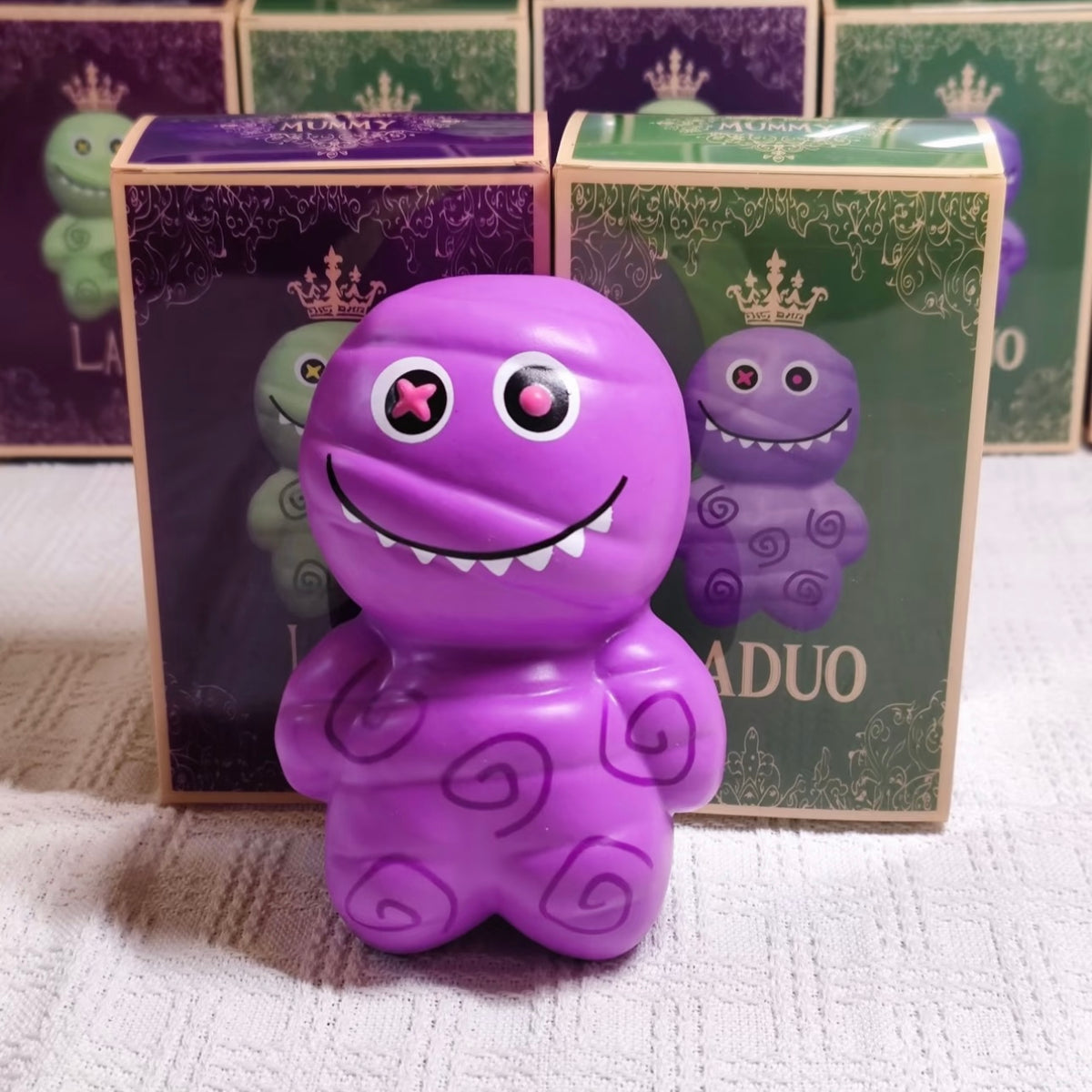Juguete sensorial antiestrés premium de momia morada con un aplastamiento súper suave y rebote lento.