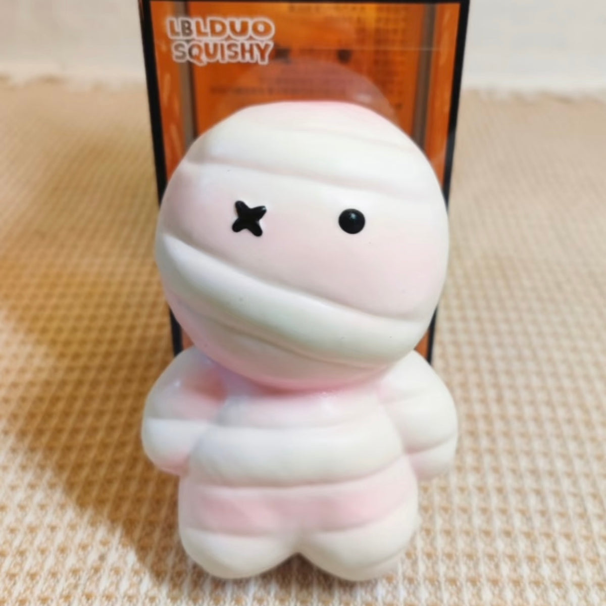 Juguete sensorial antiestrés premium de momia rosa con un aplastamiento súper suave y rebote lento.